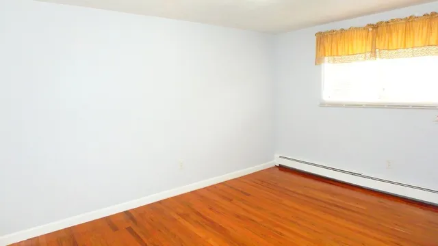 a view of a room with wooden floor and a window