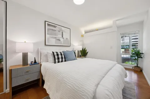 a bedroom with a large bed and a potted plant