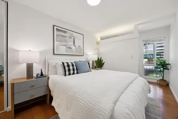 a bedroom with a large bed and a potted plant