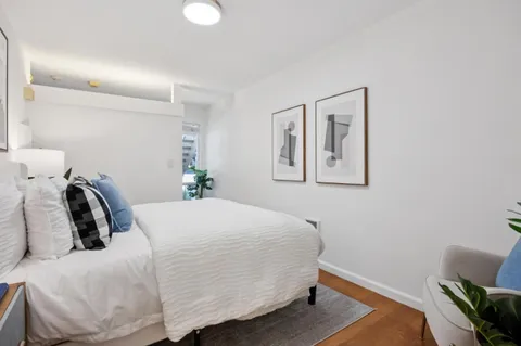 a bedroom with a bed and wooden floor