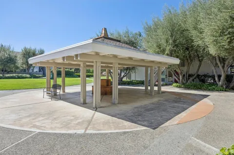 a view of a patio with a table and chairs under an umbrella