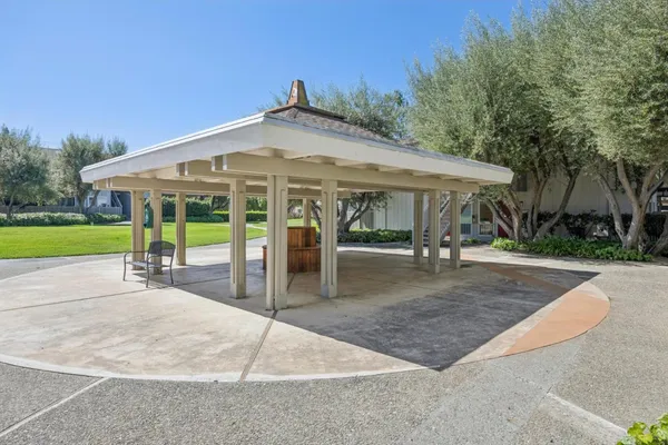 a view of a patio with a table and chairs under an umbrella