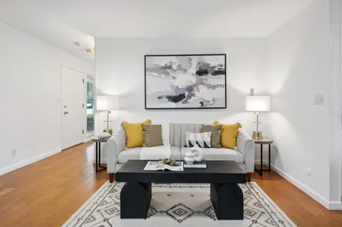 a living room with furniture and a painting on the wall