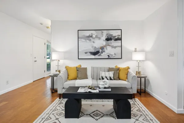 a living room with furniture and a painting on the wall