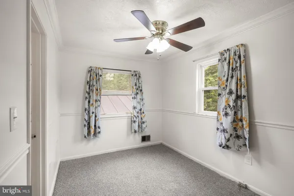 a view of a livingroom with a ceiling fan and entryway