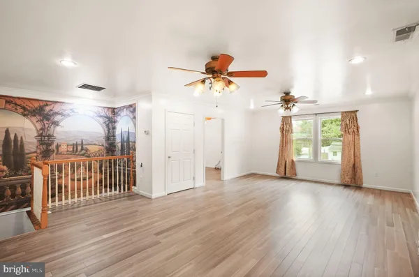 a view of a livingroom with a hardwood floor and a ceiling fan