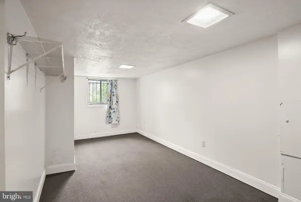 a view of a backyard with wooden fence and a large tree