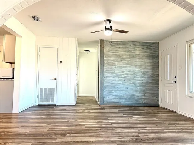 a view of empty room with wooden floor