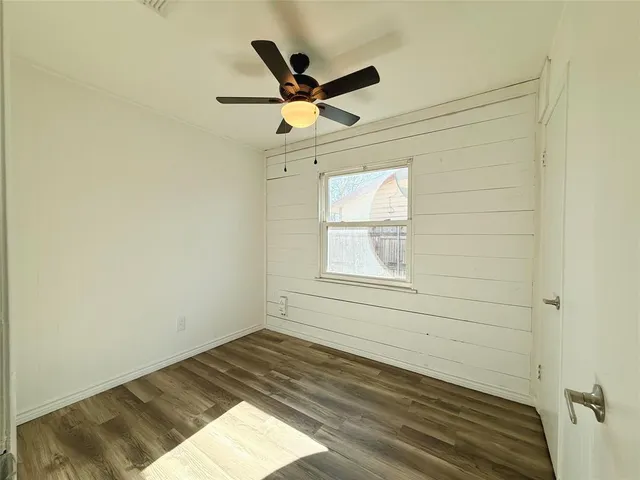 an empty room with a window and a ceiling fan