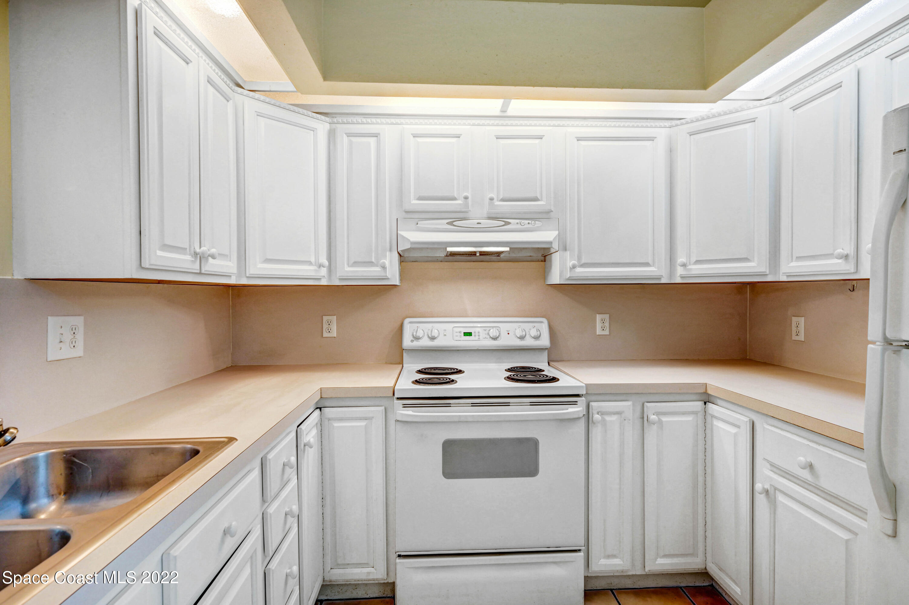 373 Myrtlewood Road Melbourne, FL 32940 - Photo 16 of 42 a kitchen with white cabinets and white appliances