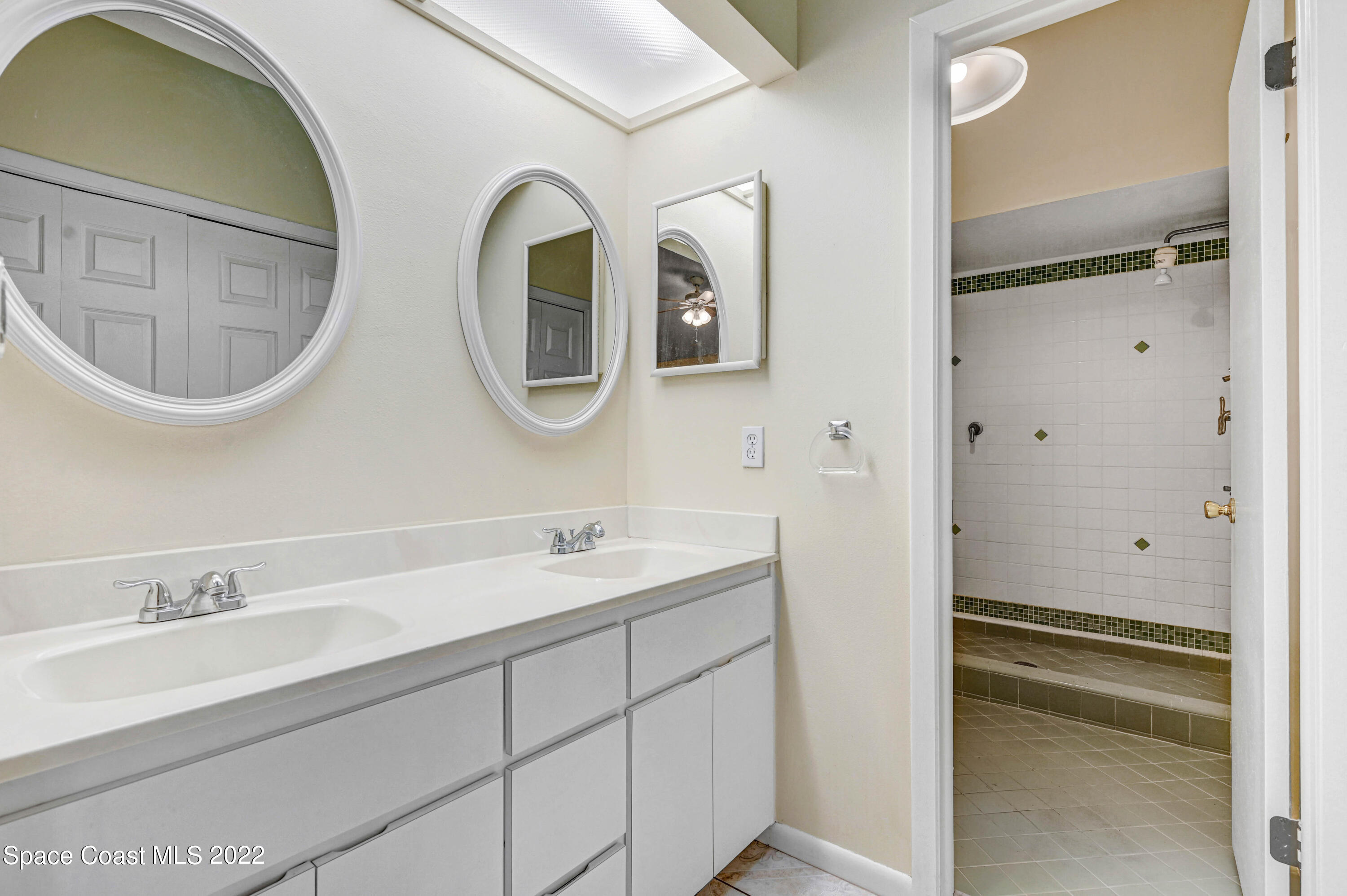 373 Myrtlewood Road Melbourne, FL 32940 - Photo 25 of 42 a bathroom with a double vanity sink and a mirror