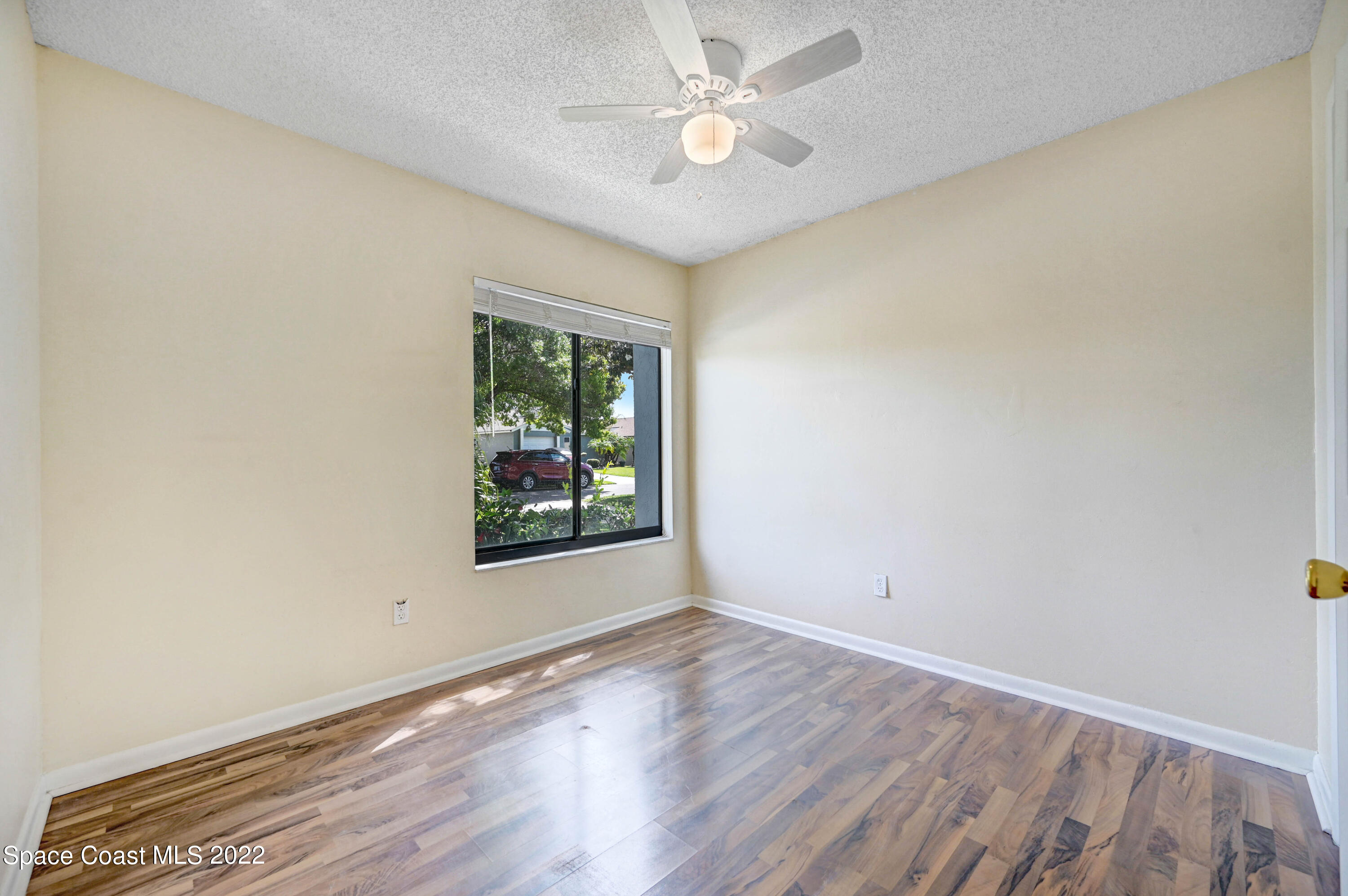 373 Myrtlewood Road Melbourne, FL 32940 - Photo 29 of 42 an empty room with wooden floor chandelier fan and windows