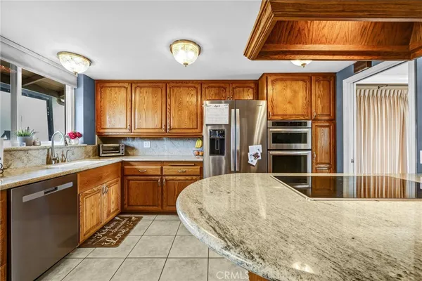 a kitchen with stainless steel appliances kitchen island granite countertop a refrigerator and stove