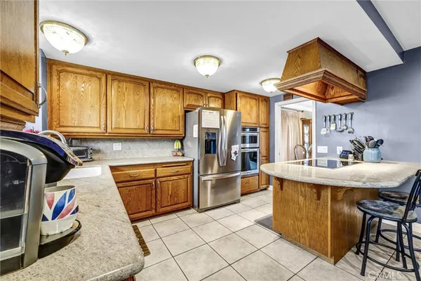 a kitchen with stainless steel appliances granite countertop a sink and a refrigerator
