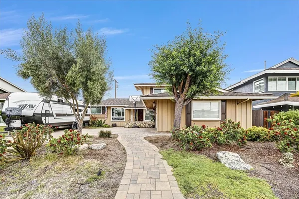 a front view of a house with a yard and trees
