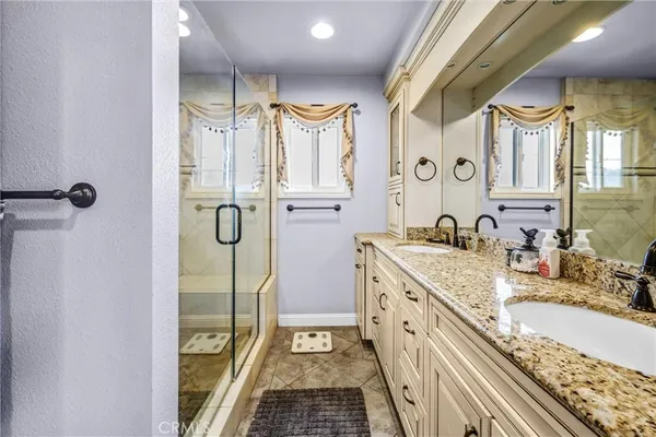 a bathroom with a granite countertop sink a toilet and a shower