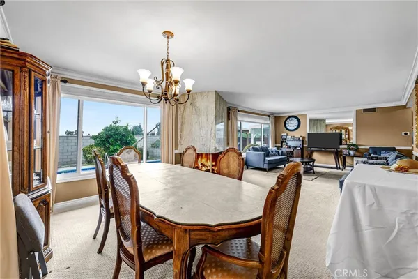 a view of a dining room with furniture and a chandelier