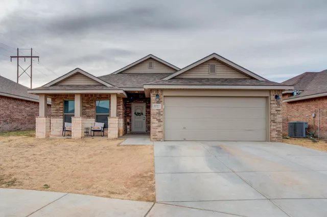 a front view of a house with yard and parking space