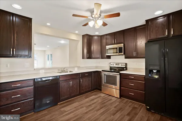 a kitchen with black cabinets stainless steel appliances and a sink