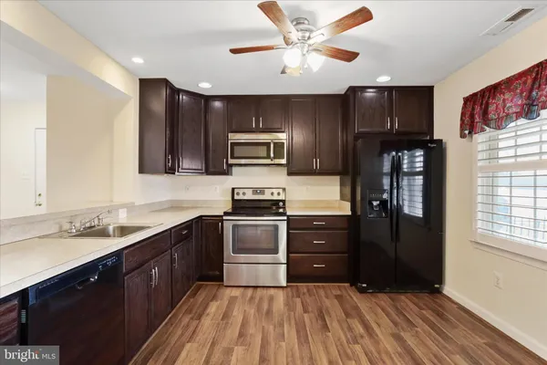 a kitchen with stainless steel appliances granite countertop a refrigerator a stove top oven a sink and dishwasher