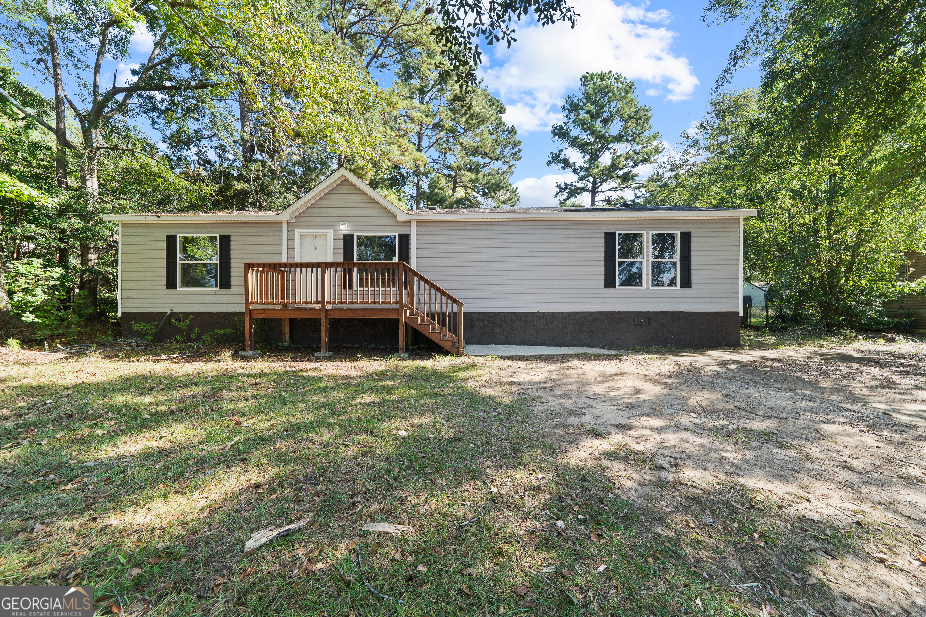 front view of a house with a yard and large trees