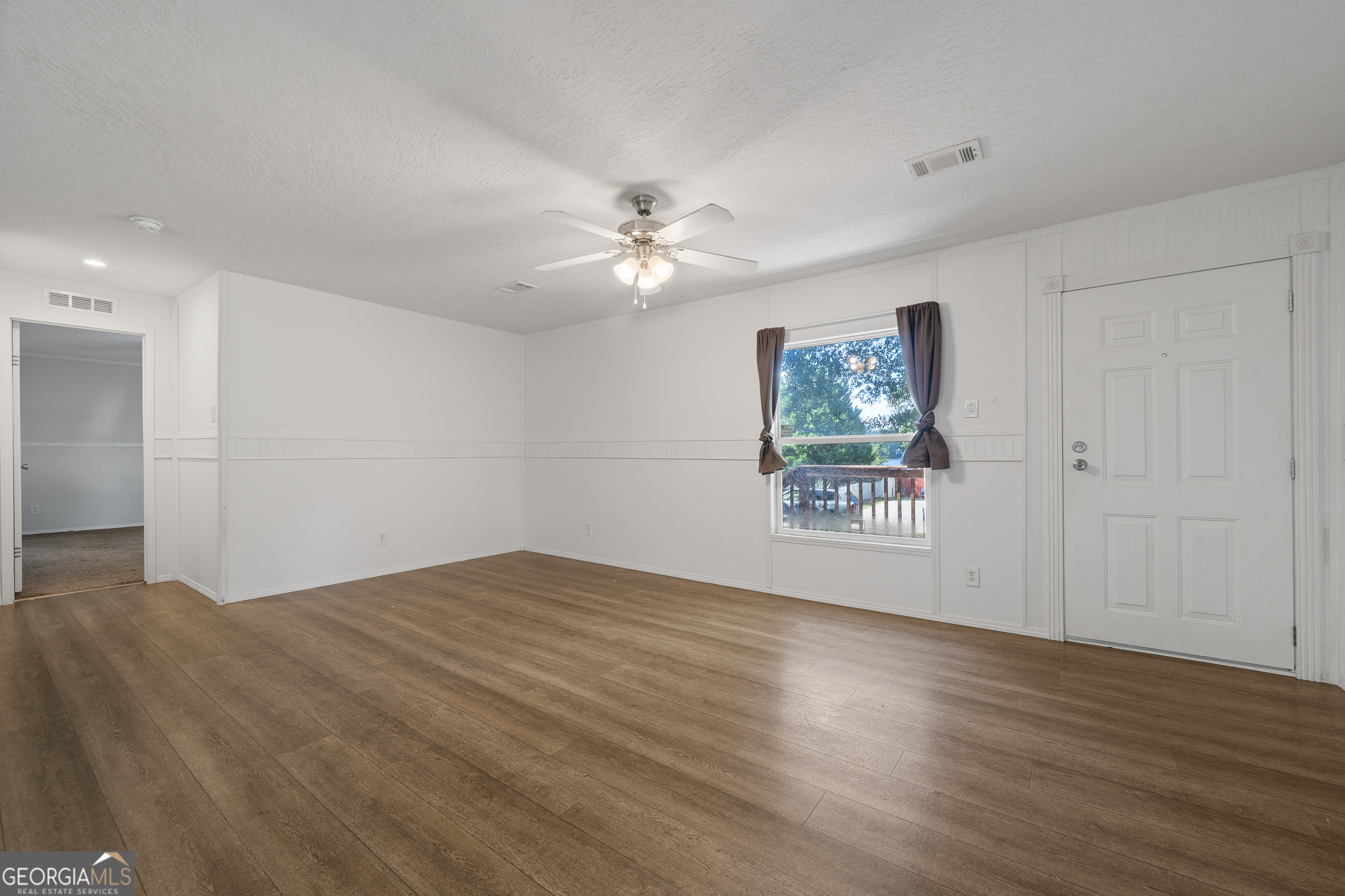 280 Lakeview Drive Locust Grove, GA 30248 - Photo 6 of 43 a view of an empty room with wooden floor