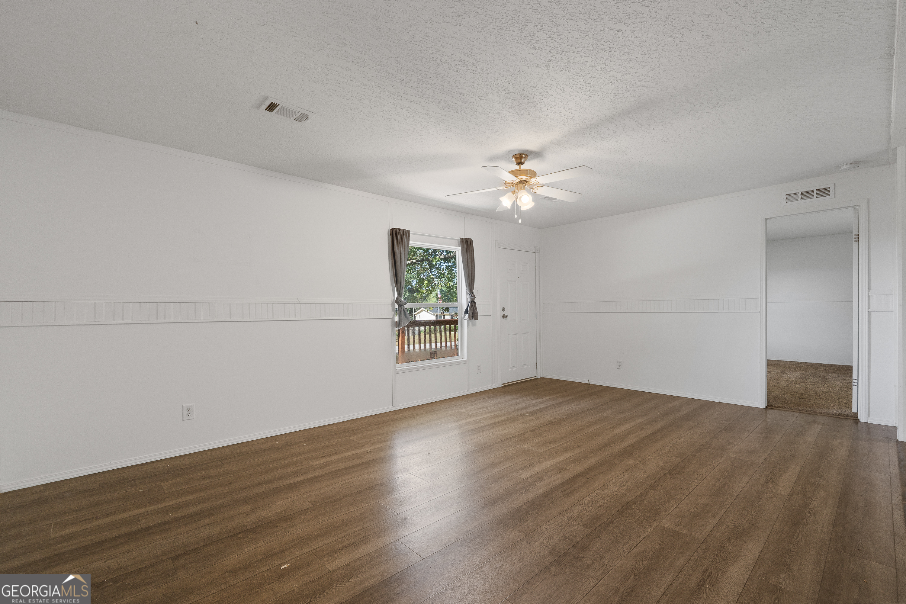 280 Lakeview Drive Locust Grove, GA 30248 - Photo 7 of 43 an empty room with wooden floor chandelier fan and windows
