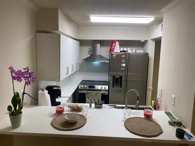 a room with a table chairs and a kitchen view