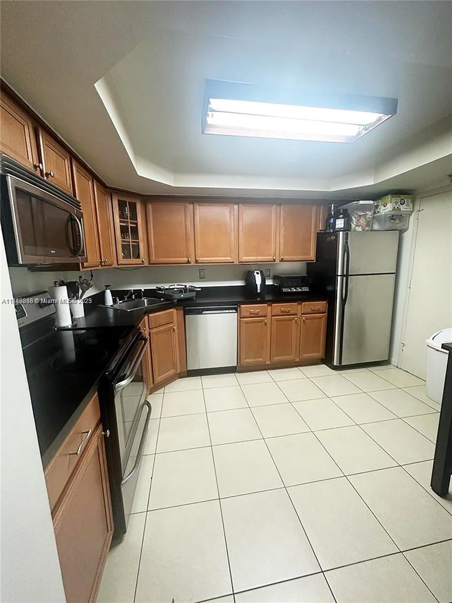 2750 Northeast 183rd Street, Unit 1404 Aventura, FL 33160 - Photo 2 of 14 a kitchen with a sink a stove top oven a refrigerator and cabinets