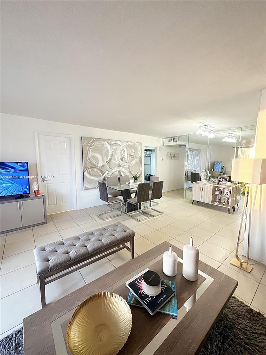 2750 Northeast 183rd Street, Unit 1404 Aventura, FL 33160 - Photo 3 of 14 a living room with furniture and a table