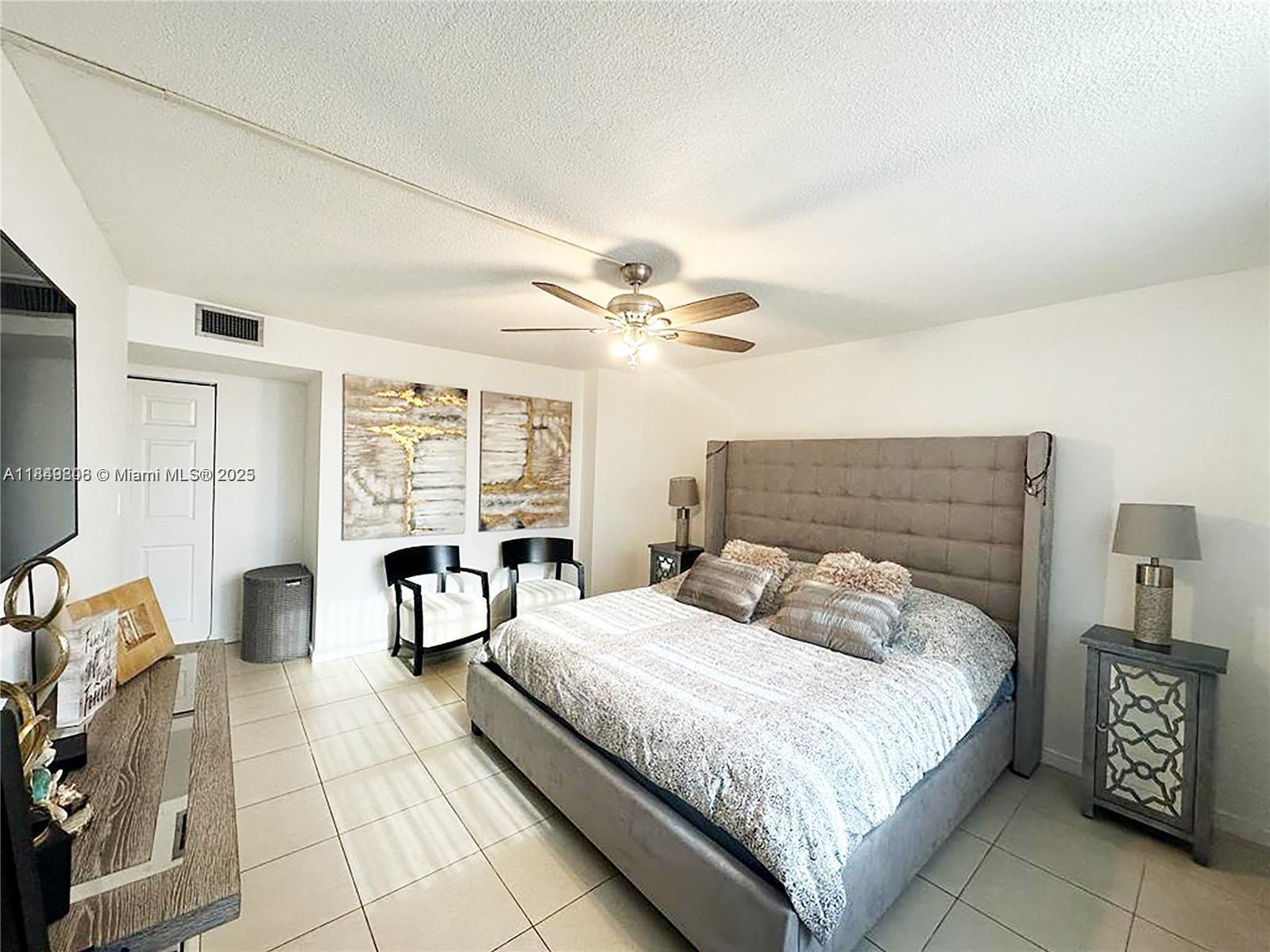 2750 Northeast 183rd Street, Unit 1404 Aventura, FL 33160 - Photo 4 of 14 a bedroom with a bed and a chandelier
