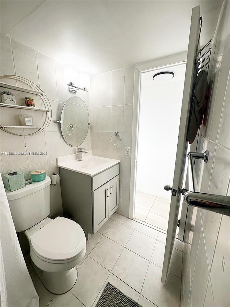 2750 Northeast 183rd Street, Unit 1404 Aventura, FL 33160 - Photo 6 of 14 a bathroom with a toilet sink and mirror