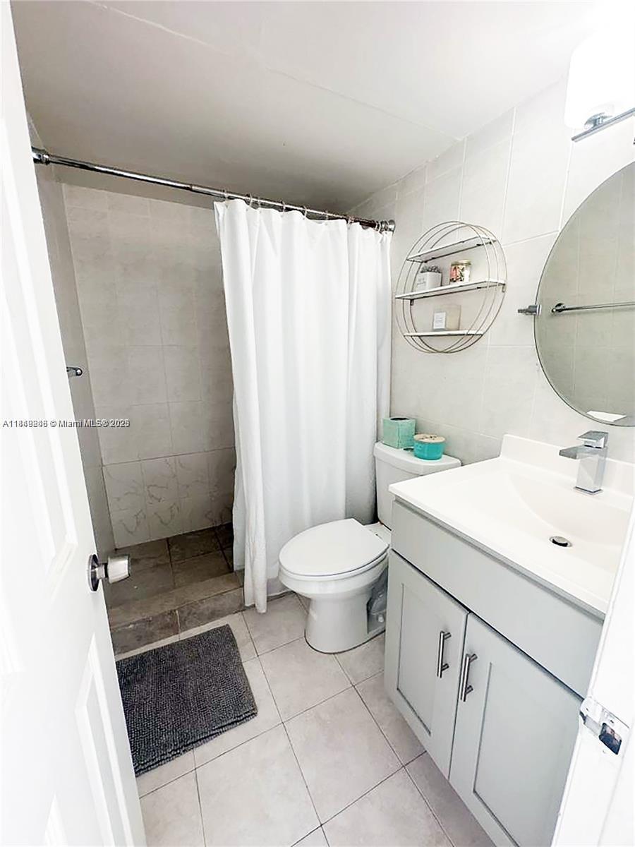 2750 Northeast 183rd Street, Unit 1404 Aventura, FL 33160 - Photo 7 of 14 a bathroom with a sink toilet and shower