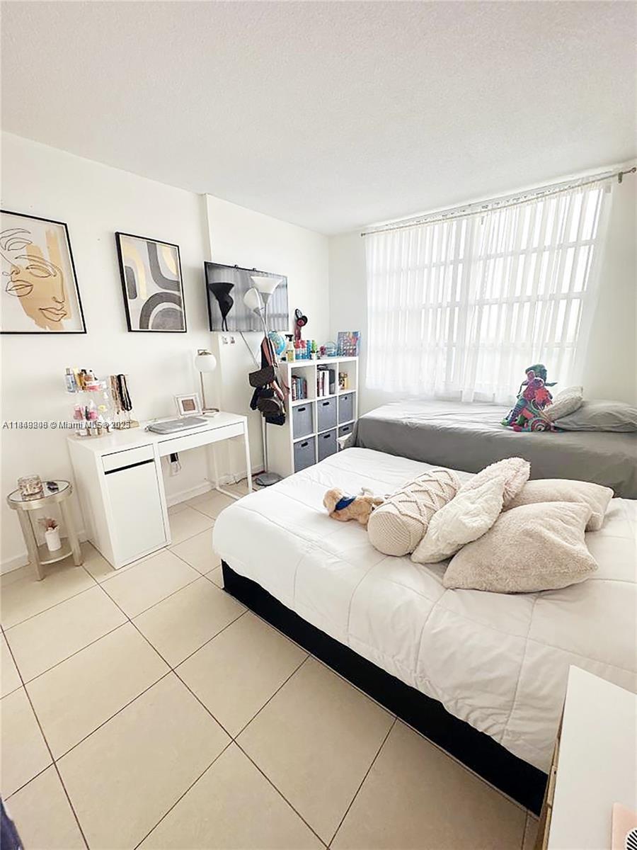 2750 Northeast 183rd Street, Unit 1404 Aventura, FL 33160 - Photo 8 of 14 a bedroom with a bed and a large window