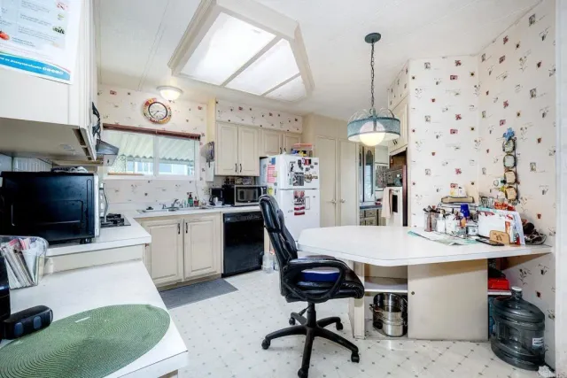 a kitchen with granite countertop white cabinets and stainless steel appliances
