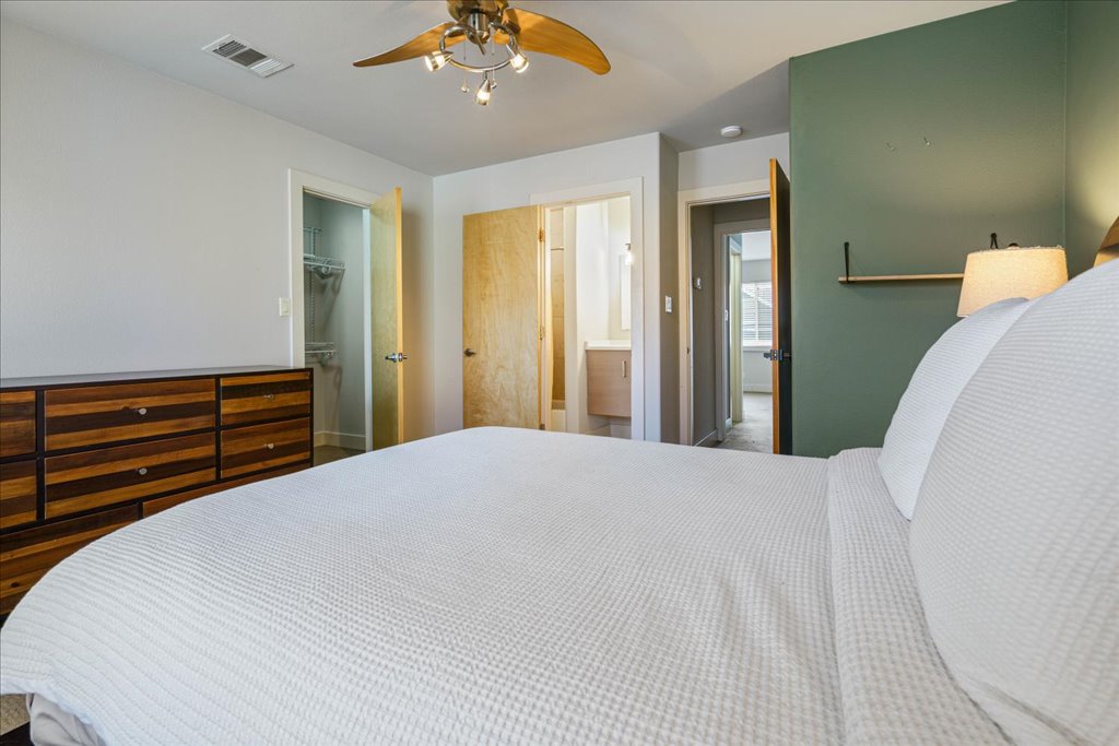 1101 Grove Boulevard, Unit 203 Austin, TX 78741 - Photo 16 of 27 a bedroom with a bed and a chandelier