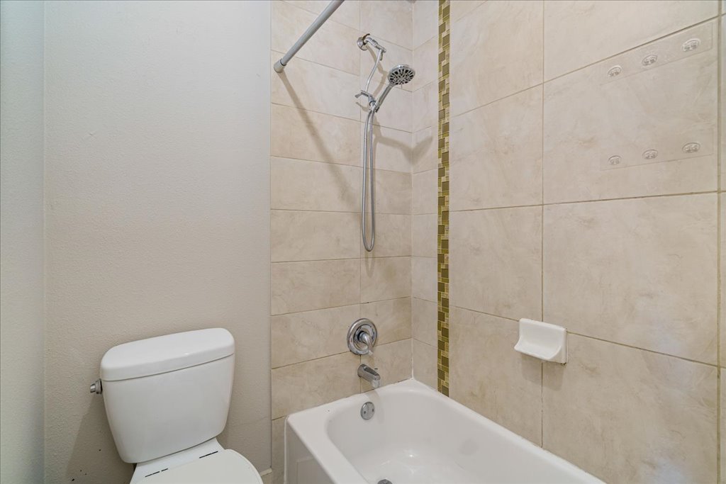 1101 Grove Boulevard, Unit 203 Austin, TX 78741 - Photo 18 of 27 a bathroom with a sink a toilet and shower