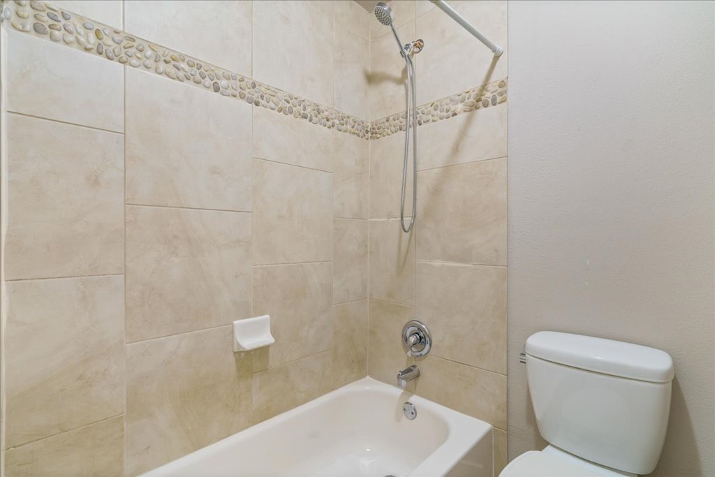 1101 Grove Boulevard, Unit 203 Austin, TX 78741 - Photo 22 of 27 a bathroom with a toilet and shower