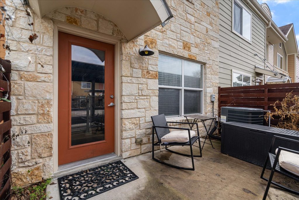 1101 Grove Boulevard, Unit 203 Austin, TX 78741 - Photo 24 of 27 a view of a patio with table and chairs and wooden floor