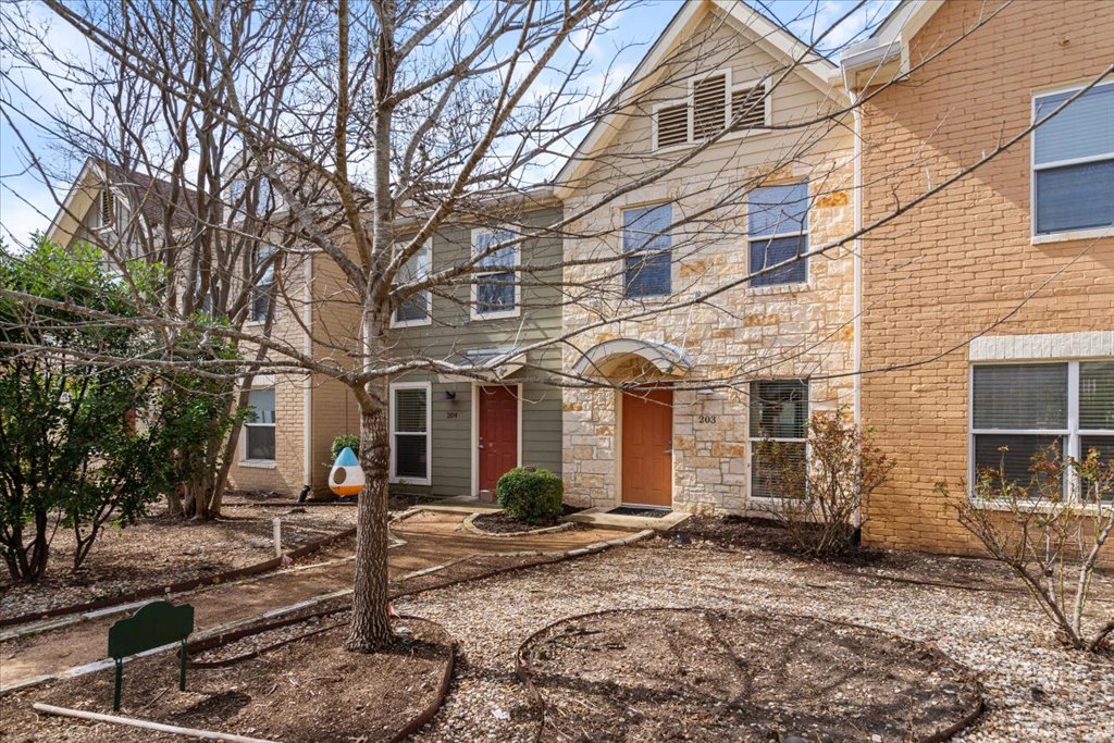 1101 Grove Boulevard, Unit 203 Austin, TX 78741 - Photo 3 of 27 a front view of a house with garden