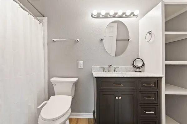 a bathroom with a toilet a sink and mirror