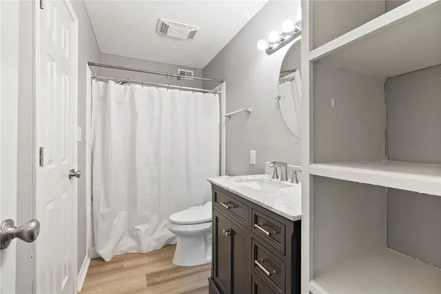 a bathroom with a granite countertop sink toilet and shower