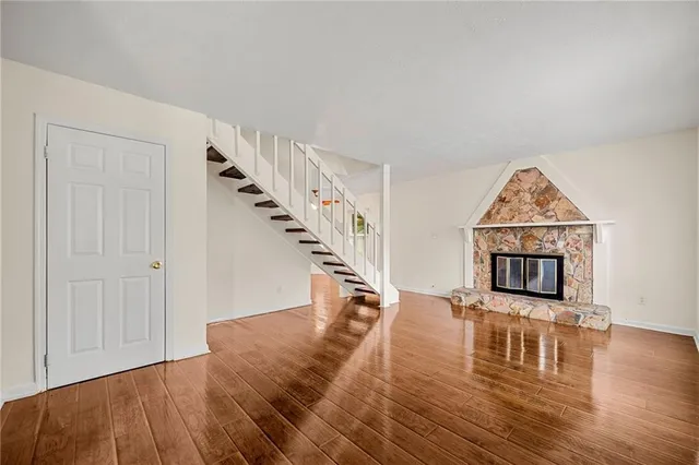a view of a livingroom with wooden floor and a hallway