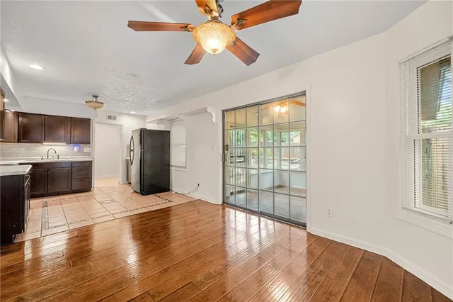 a view of an empty room with window and wooden floor