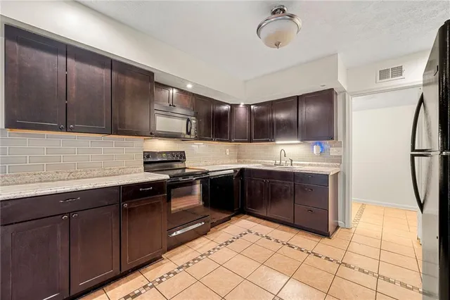 a kitchen with stainless steel appliances granite countertop a sink stove and refrigerator