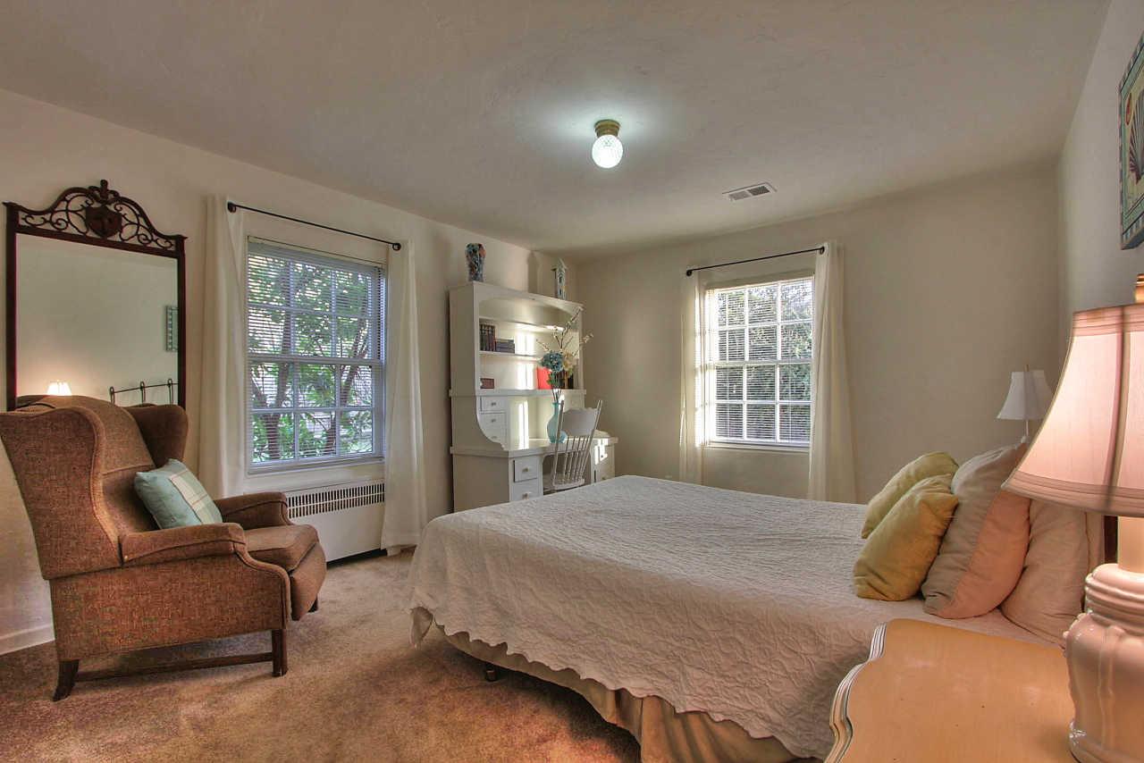 3035 Valdez Road Pebble Beach, CA 93953 - Photo 27 of 60 a bedroom with a bed and a couch next to a window
