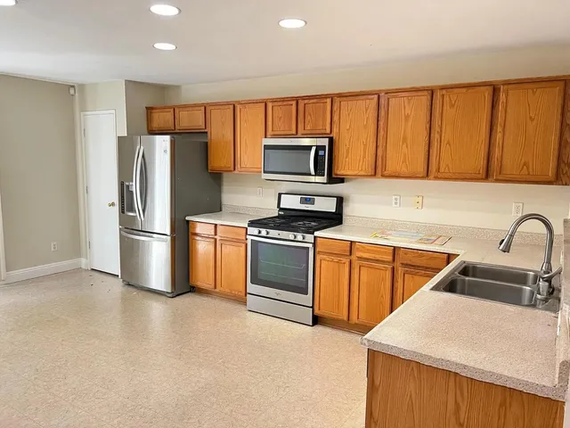 a kitchen with stainless steel appliances a refrigerator sink and microwave
