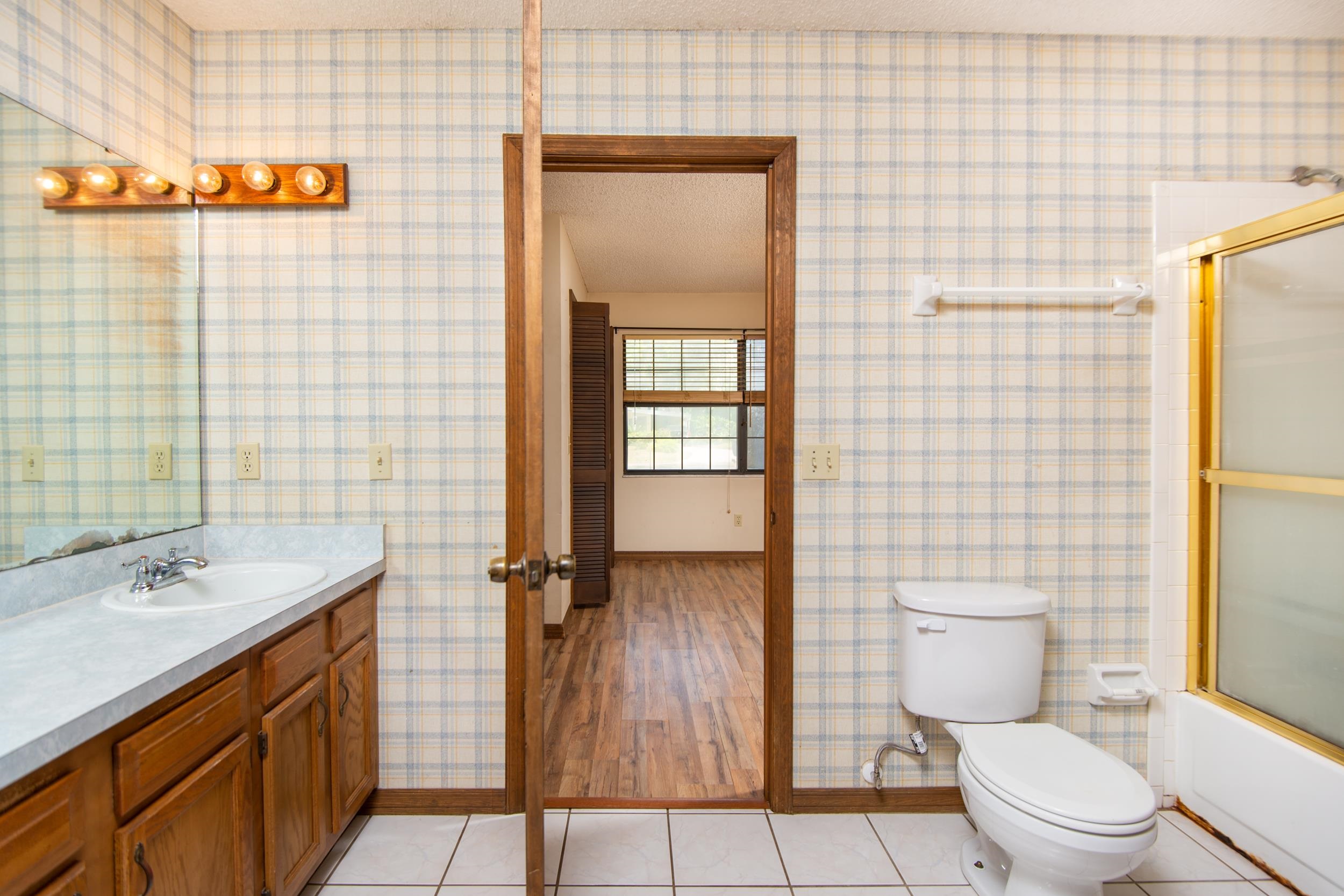 328 Linden Road St. Augustine, FL 32086 - Photo 11 of 62 a bathroom with a granite countertop toilet a sink a mirror and shower