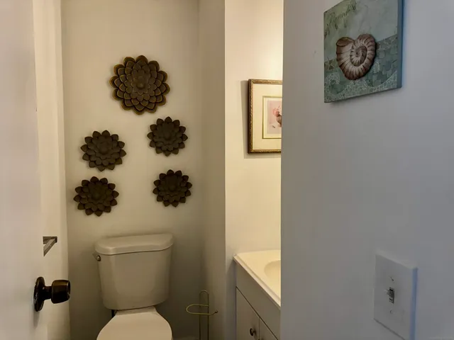 a bathroom with a toilet and a picture on the wall