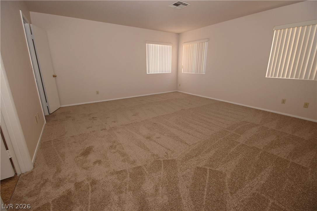 8220 Maplestar Road Las Vegas, NV 89128 - Photo 29 of 29 A spacious room offers ample natural light through well-placed windows.